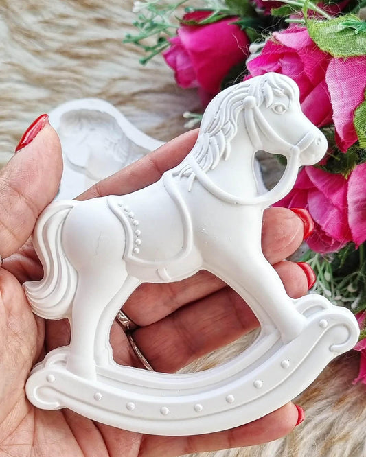 Molde de cavalinho branco em forma de cavalo de baloiço, na mão