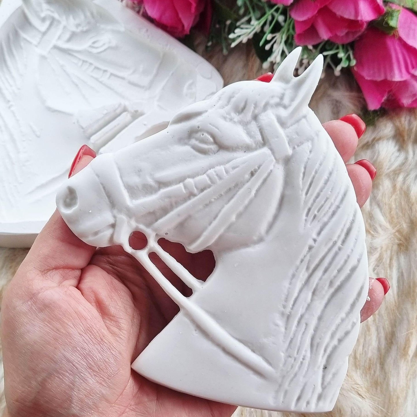 Molde de cabeça de cavalo branco com relevo e orifícios, em close-up