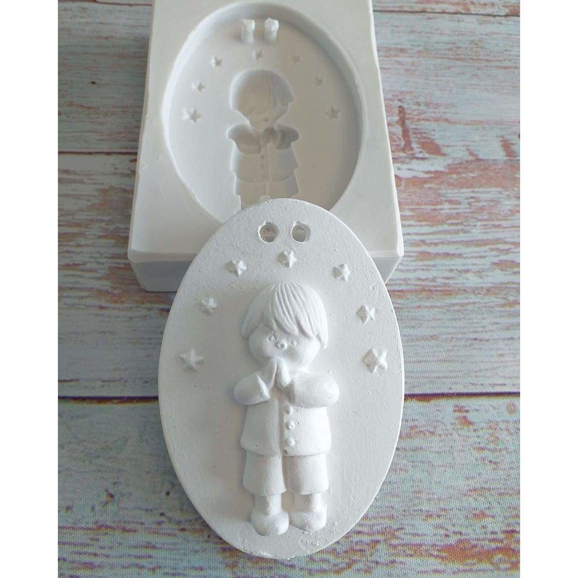 Molde oval de menino a rezar, com figura em relevo e detalhes no contorno