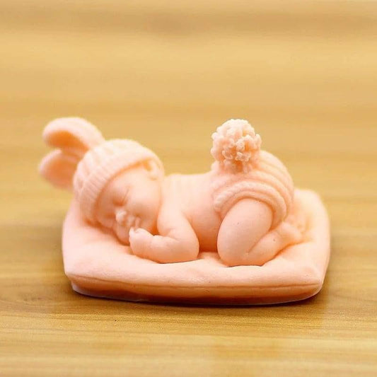 Bebé deitado na almofada rosa, com gorro e meias listradas