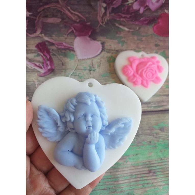 Forma em coração com anjo em relevo, azul claro, segurada na mão