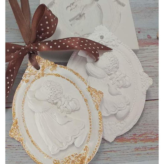 Molde 2D de anjo em relevo, oval branco com contorno dourado e laço castanho