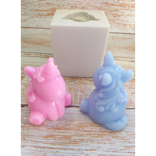 Molde 3D de unicórnio sentado com peça branca e duas figuras rosa e azul
