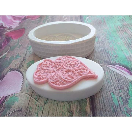 Molde oval de silicone com coração de Viana em relevo, rosa claro, visto de cima.