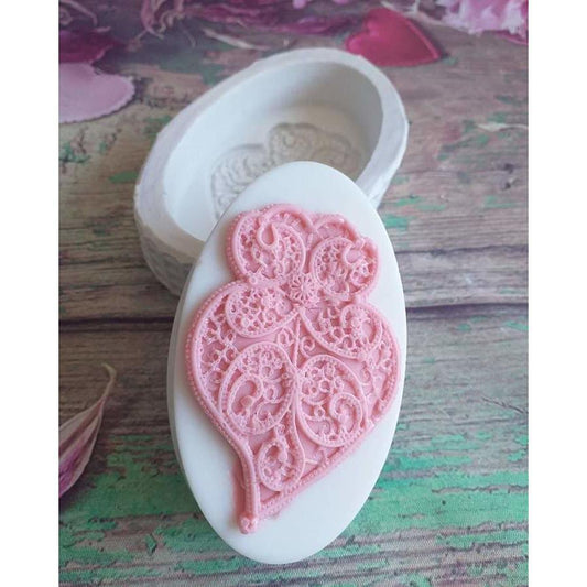 Molde oval de silicone com coração de Viana em relevo rosa claro.