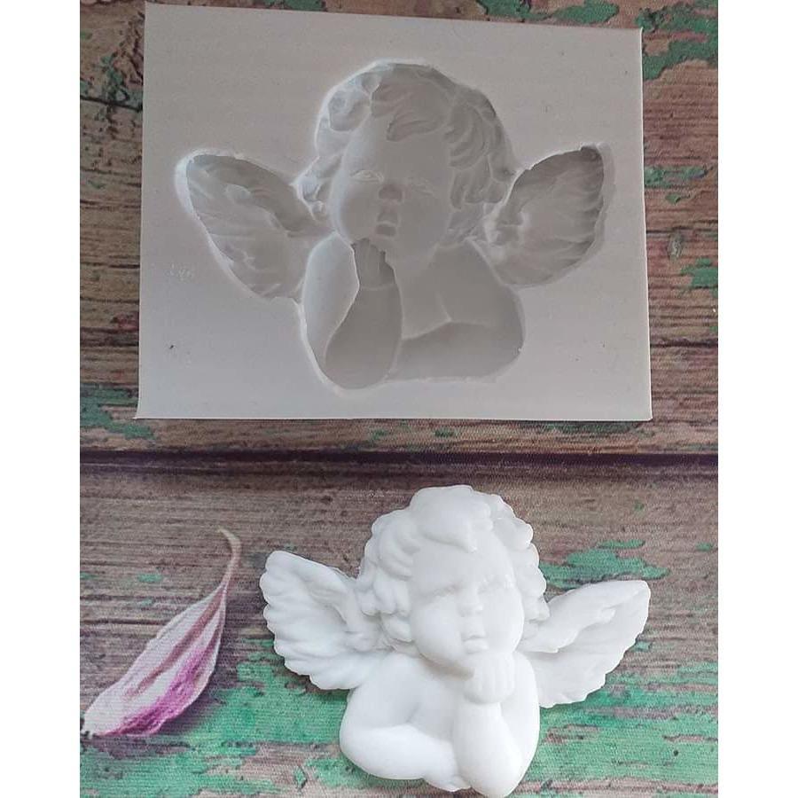 Molde de anjo em relevo, com a mão no queixo, em branco