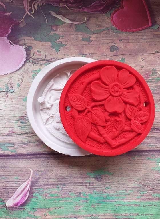 Molde redondo de silicone com flores em relevo e 2 furos, vermelho sobre branco