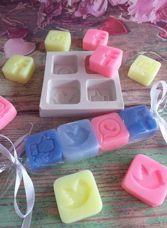 molde de silicone para sabão com cavidades e sabonetes rosa e azul em destaque