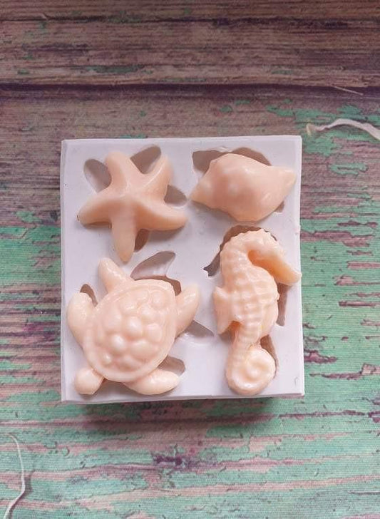 Molde de silicone marinho com figuras em tons de bege: estrela, concha, peixe