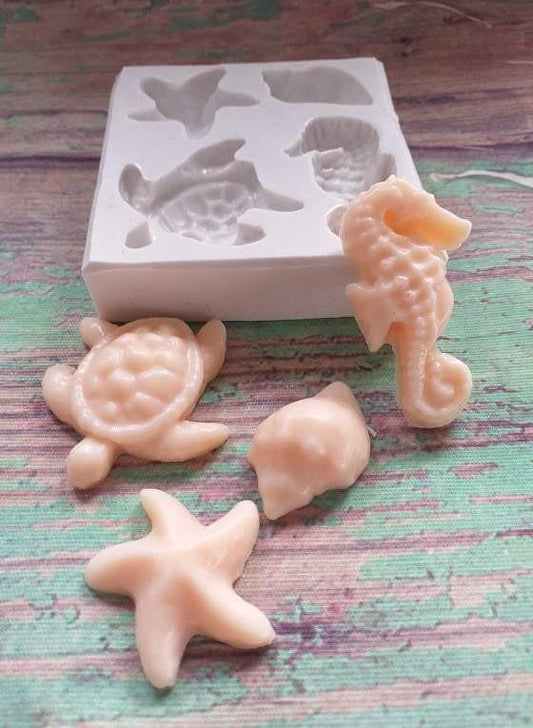 Molde de silicone marinho com cavidades e peças em bege e cinzento