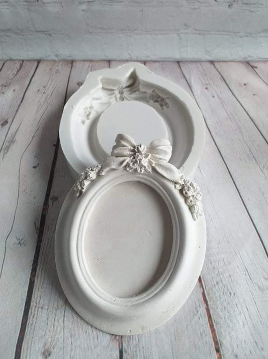 Molde de moldura oval branca com laço e ornamentos florais, formato duplo