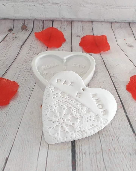 Molde de coração branco com textura rendada em relevo e inscrição 'PAZ'