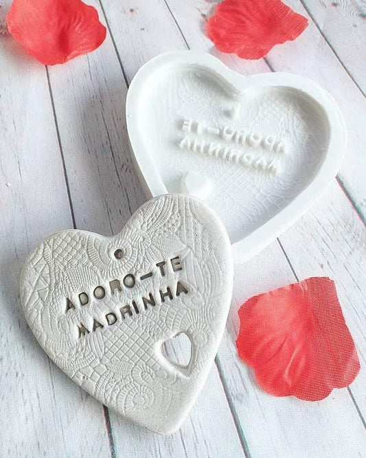 Molde em forma de coração branco com texto em relevo “Adoro-te Madrinha”.