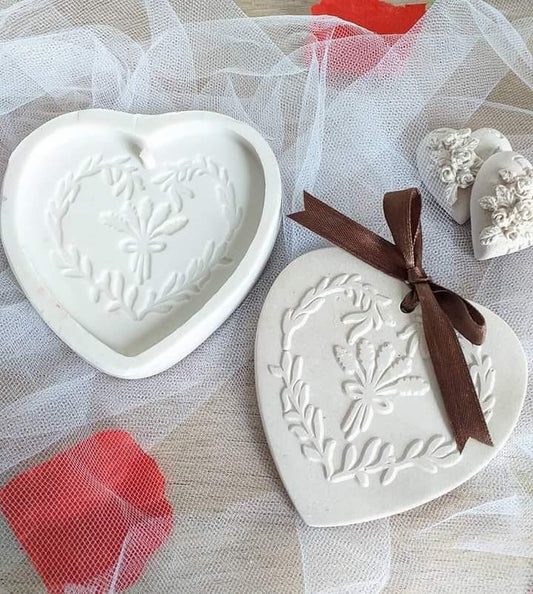 Molde em forma de coração branco com relevo floral e folhagens, dois exemplares