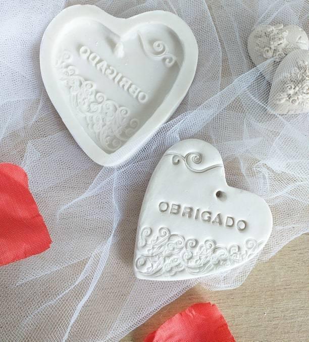 Molde em forma de coração branco com relevo e texto «OBRIGADO»