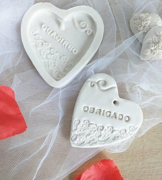 Molde em forma de coração branco com relevo e texto «OBRIGADO»