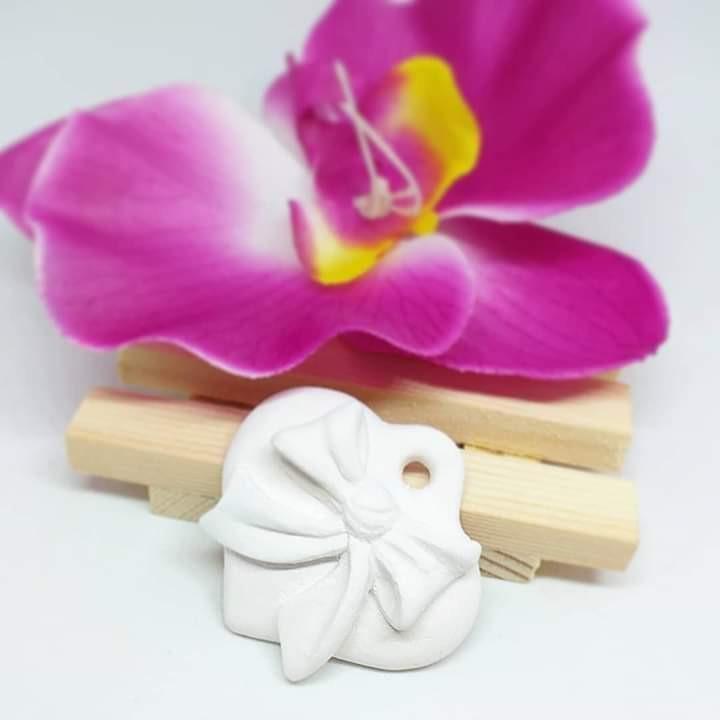 Molde em forma de coração branco com laço, assente em suporte de madeira