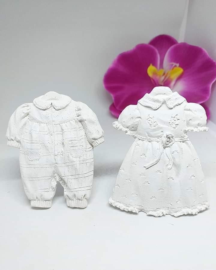 Par de vestidos brancos infantis com bordado e folhos, vistos de frente