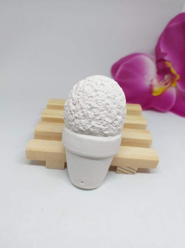 Molde em forma de vaso branco com topo texturado, assente em base de madeira