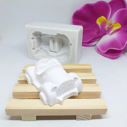 Molde de carrinho branco com peça em forma de automóvel sobre base de madeira