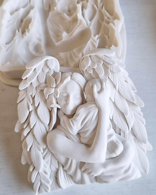 Decoração branca em forma de anjo com asas e figura de bebé entrelaçada