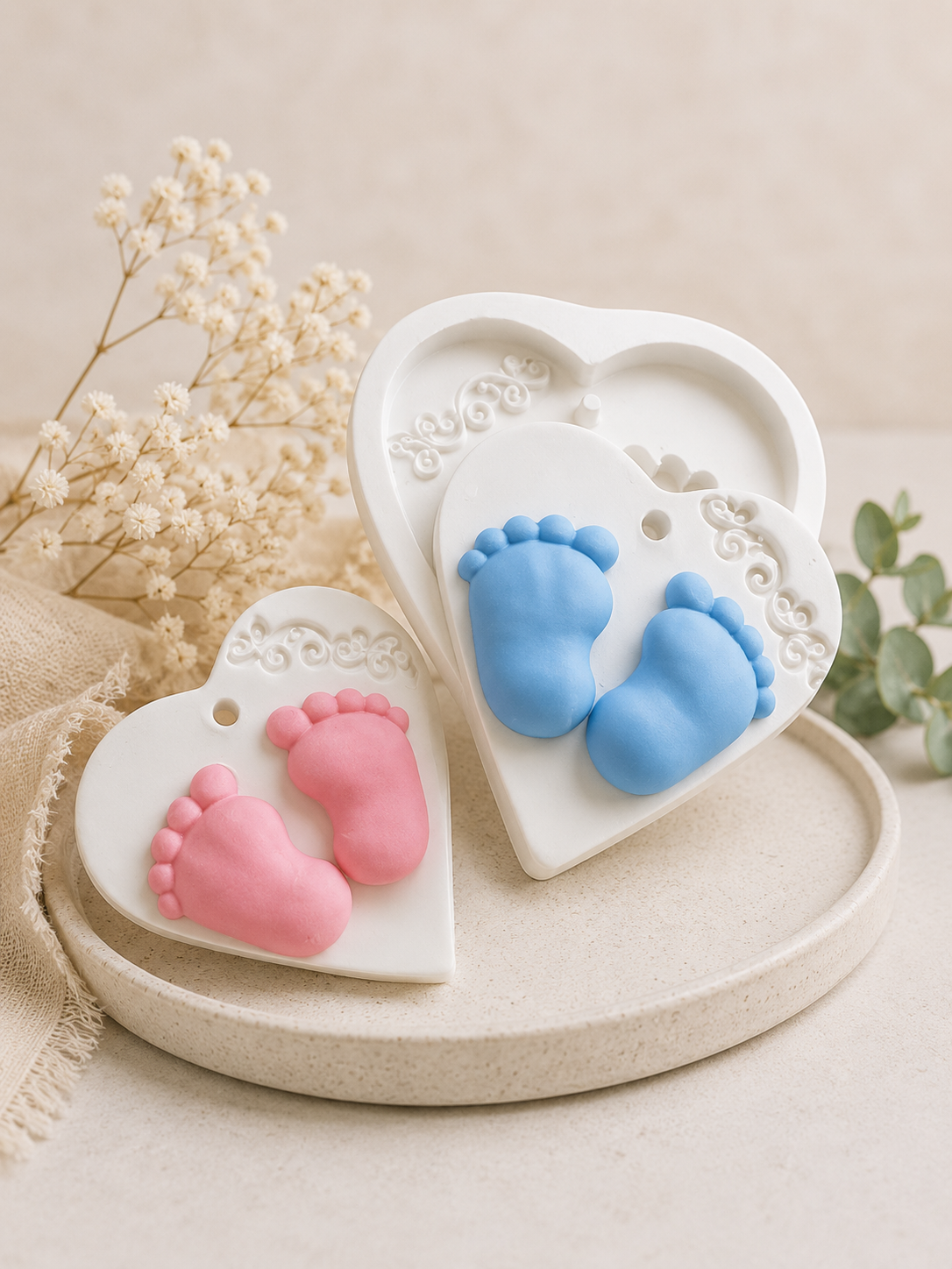 Molde em forma de coração com cavidades de pezinhos, com pés em tons azul e rosa