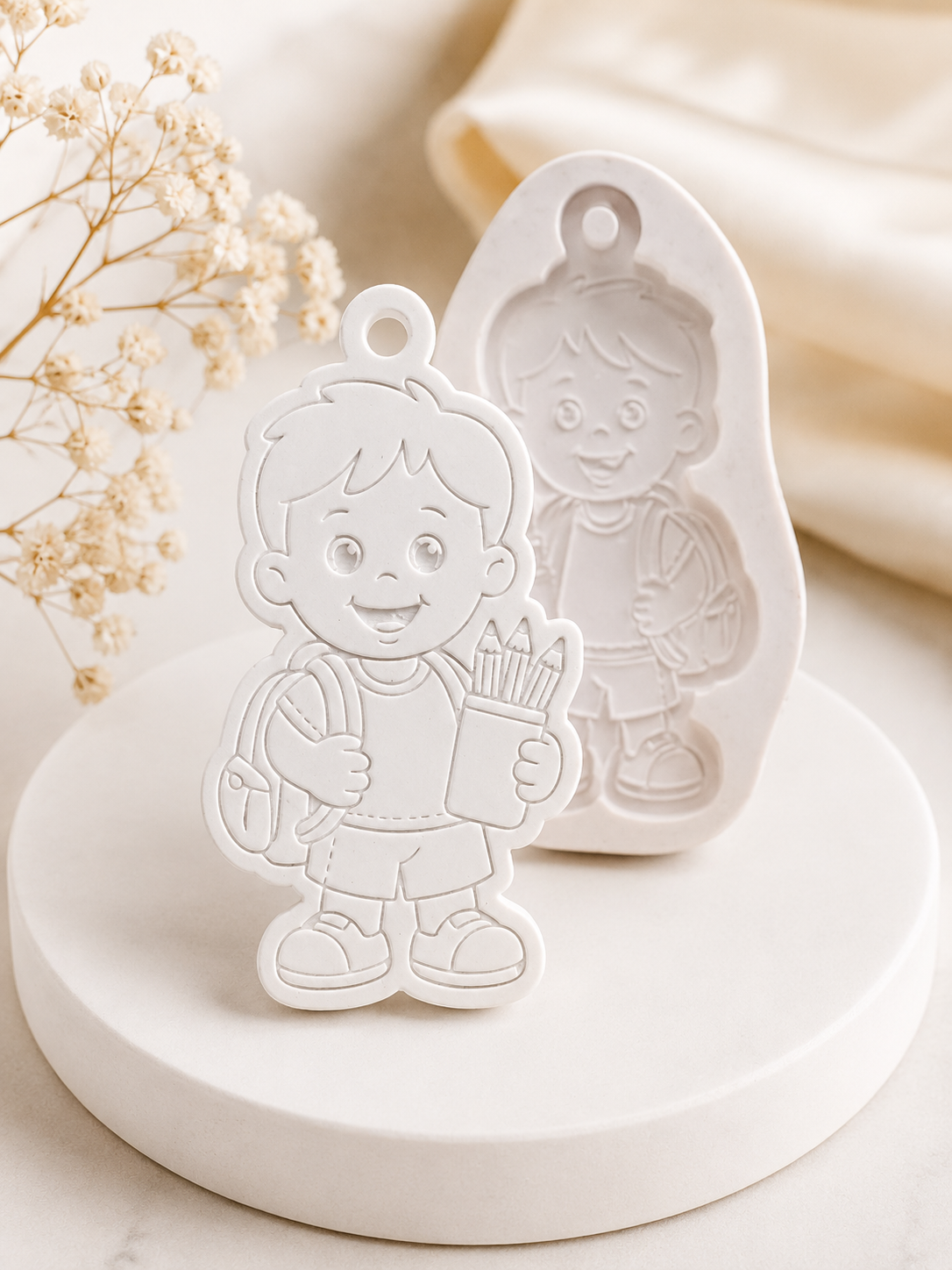 Molde de silicone com desenho de menino e uma segunda figura, ambos com lápis