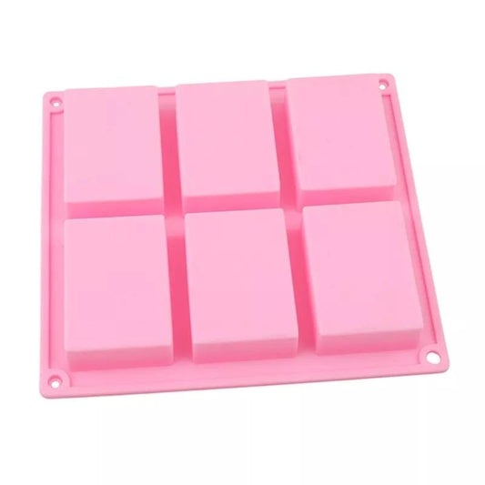 Molde rosa de silicone com 6 cavidades retangulares e furos nas esquinas