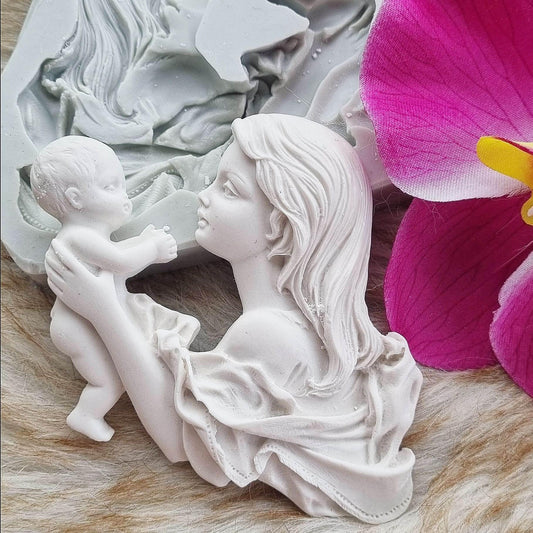 Figura branca de mãe com bebé ao colo, em relevo, rosto de perfil