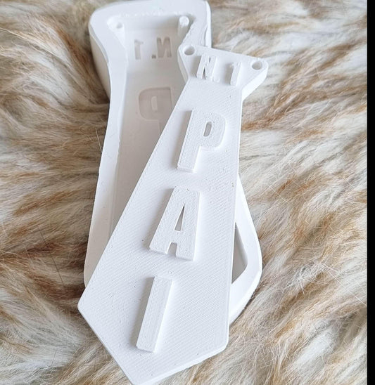 Molde de gravata branco com letras 'PAI' em relevo.